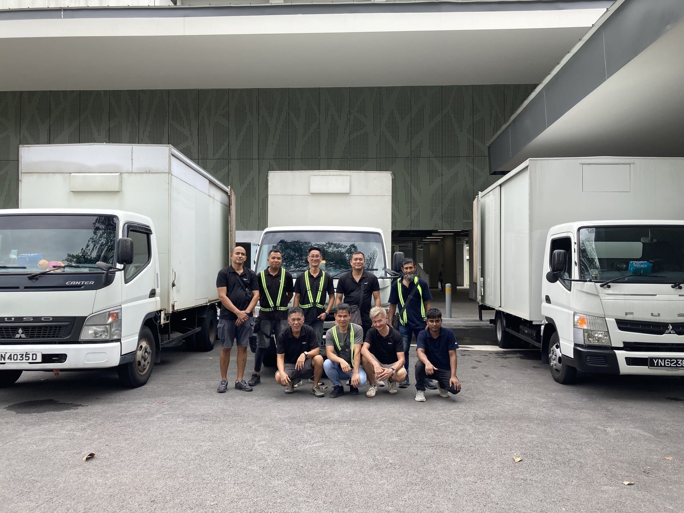 The Reddot Movers crew in front of three moving trucks
