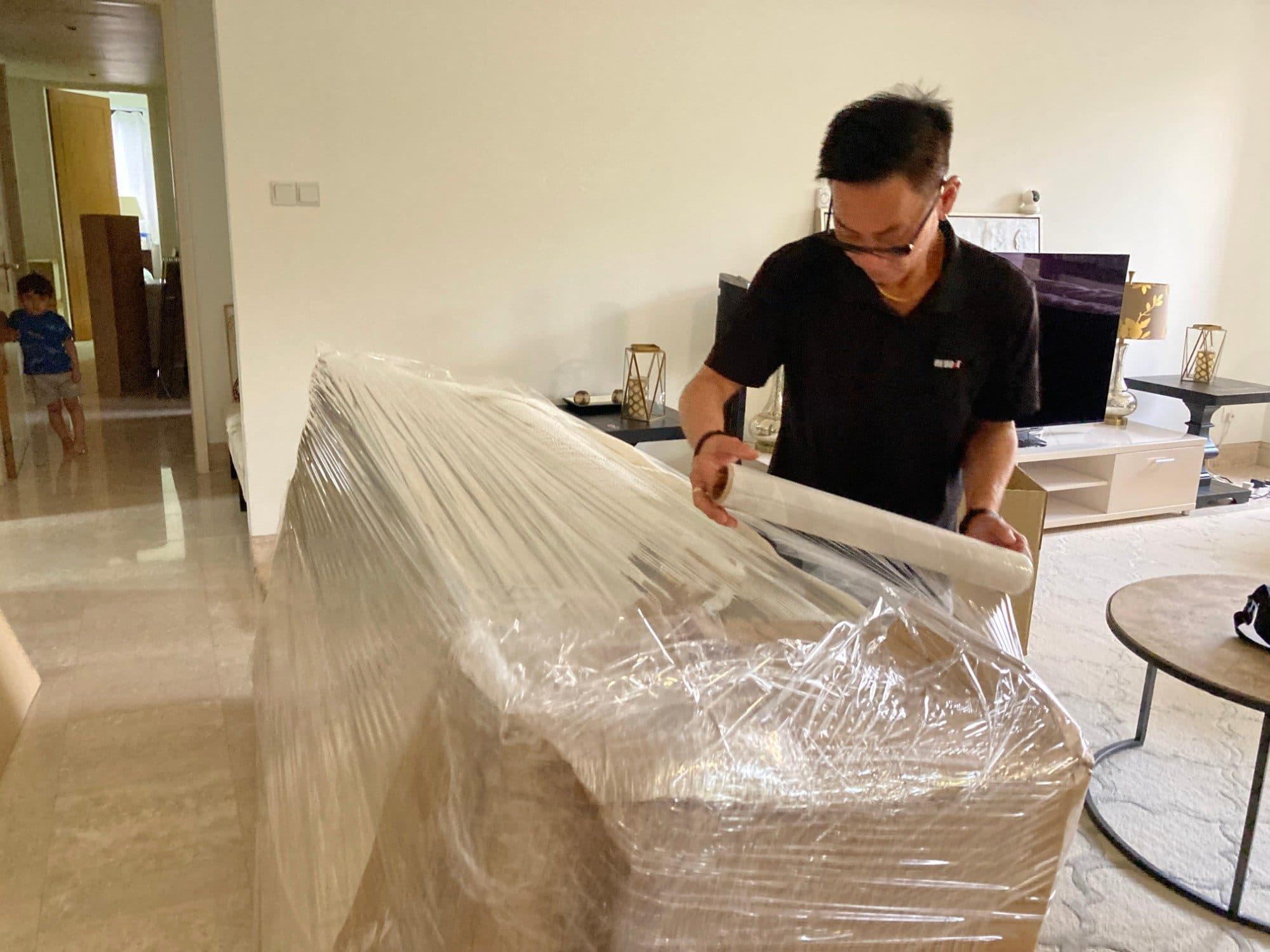 A Reddot packer stretch-wrapping a large item in a living room