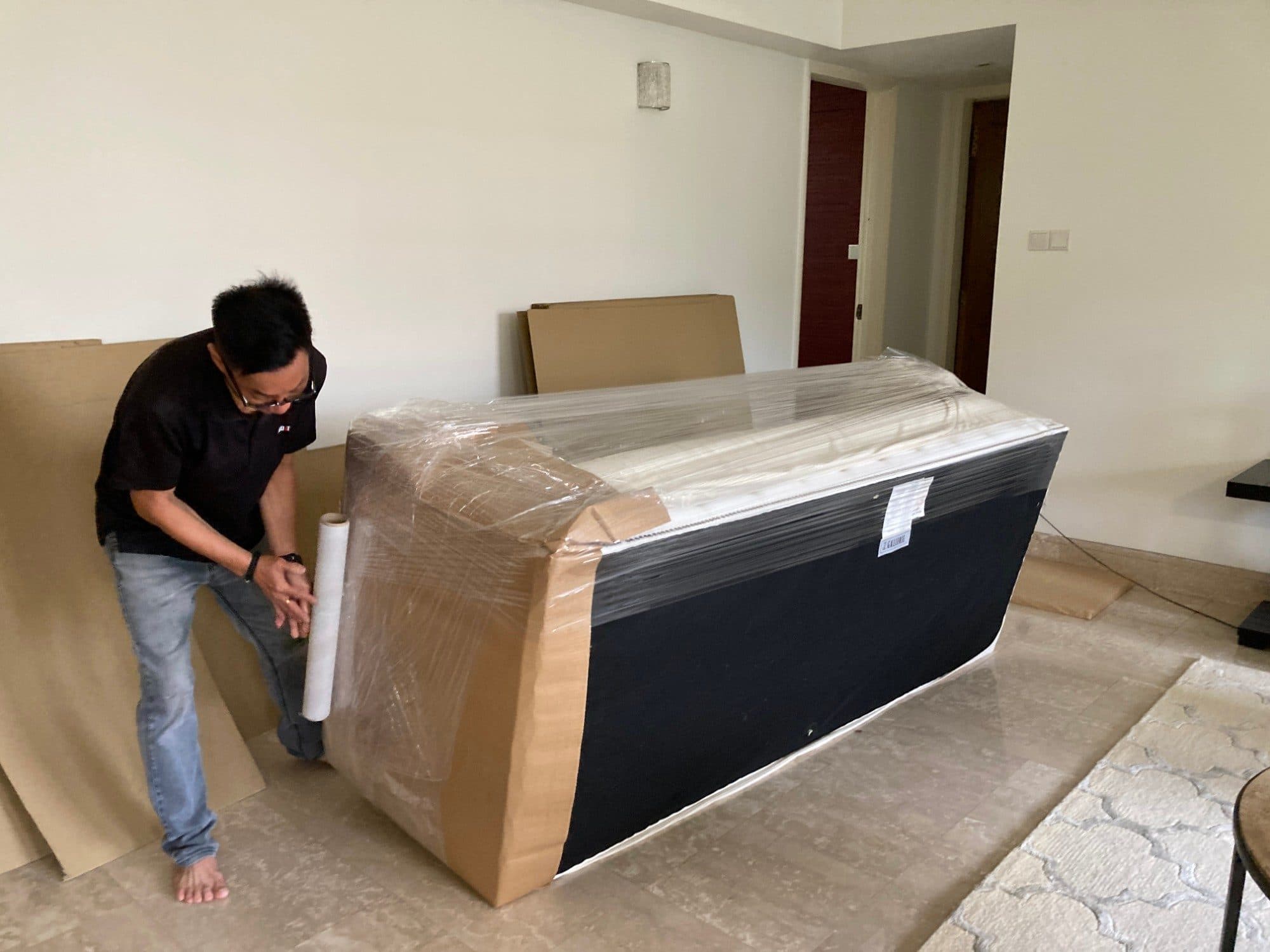 A Reddot packer stretch-wrapping a sofa protected with cardboard corners
