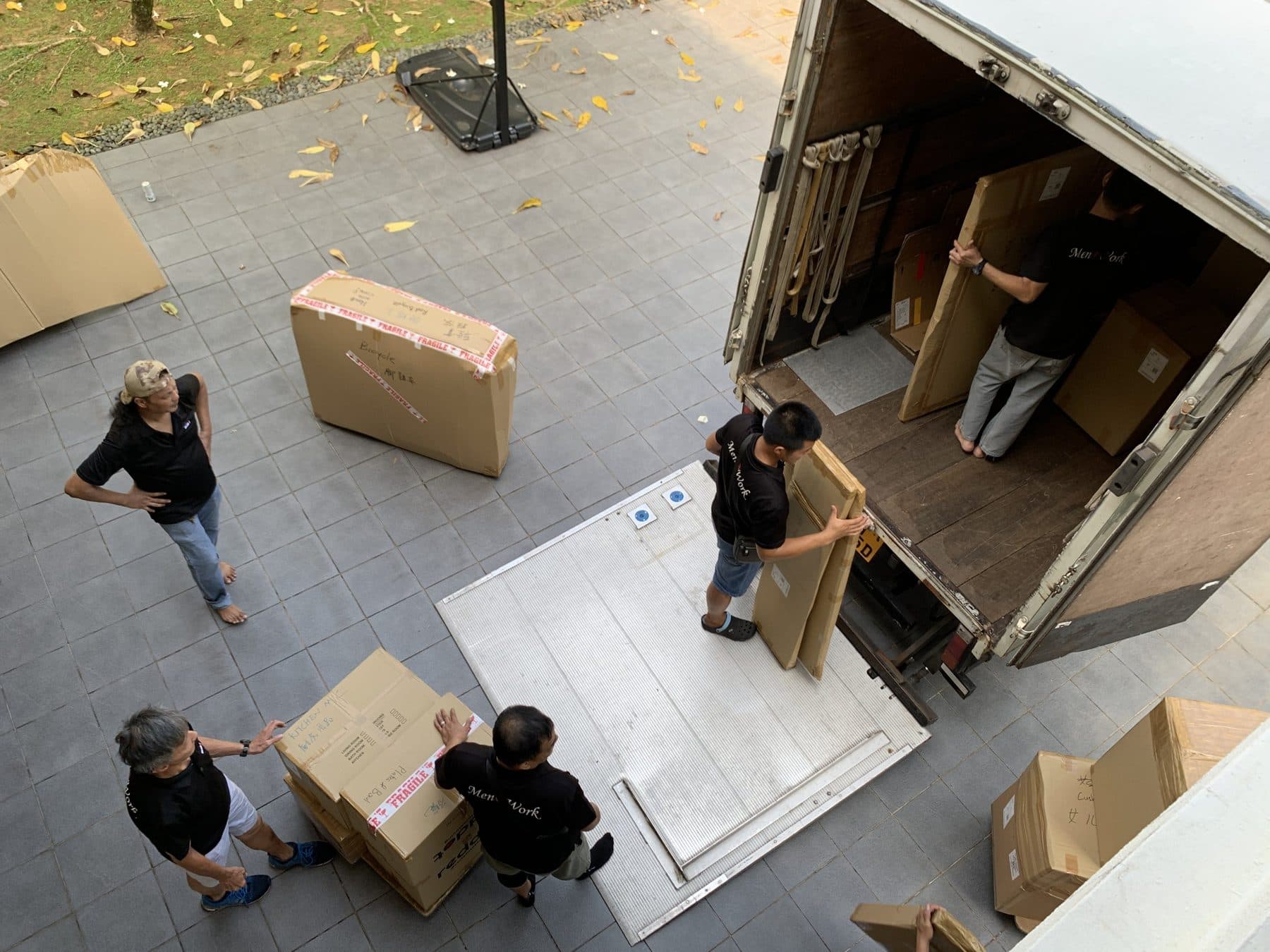 Reddot movers loading a truck in a house driveway, seen from above