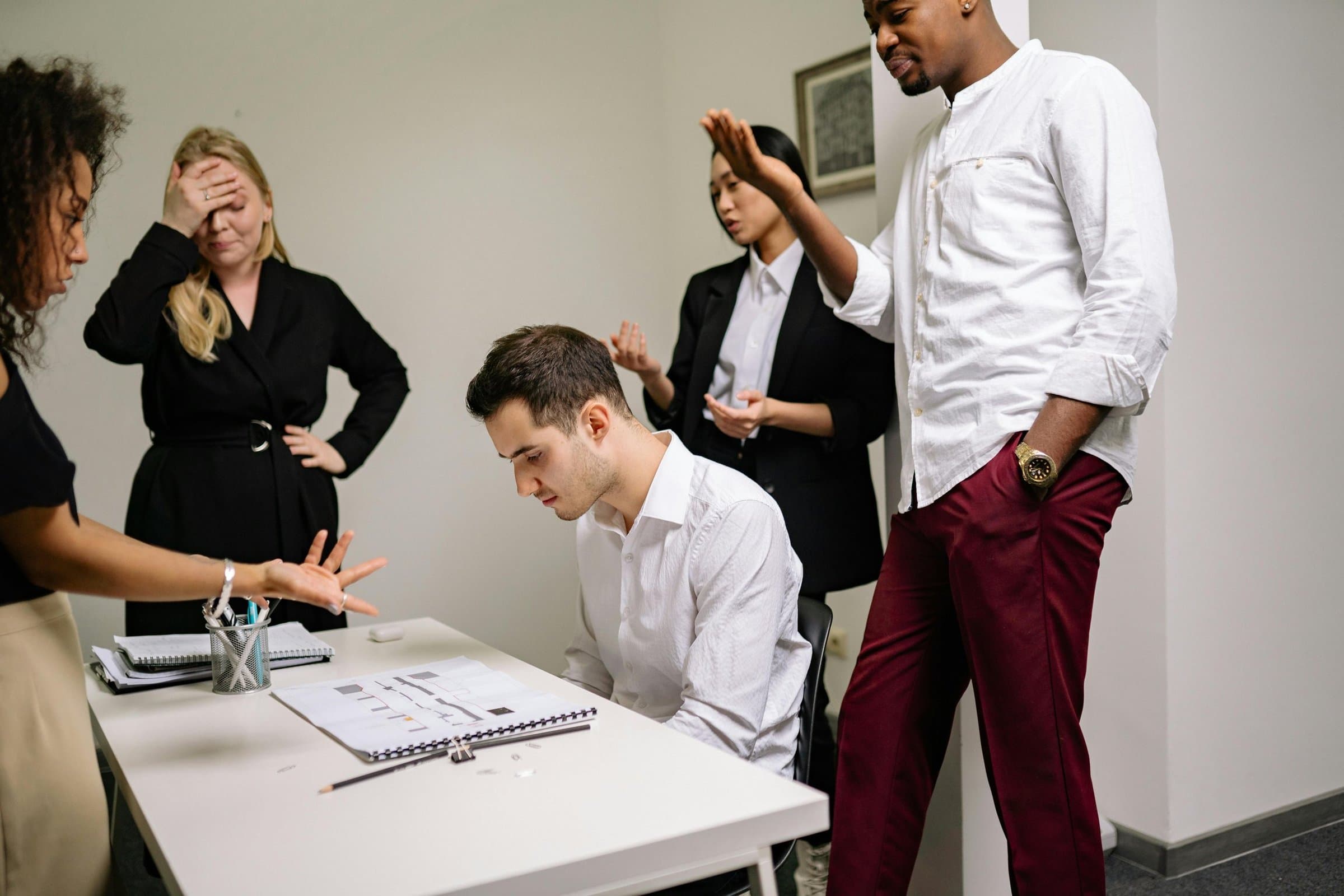 Office colleagues looking stressed around a meeting table