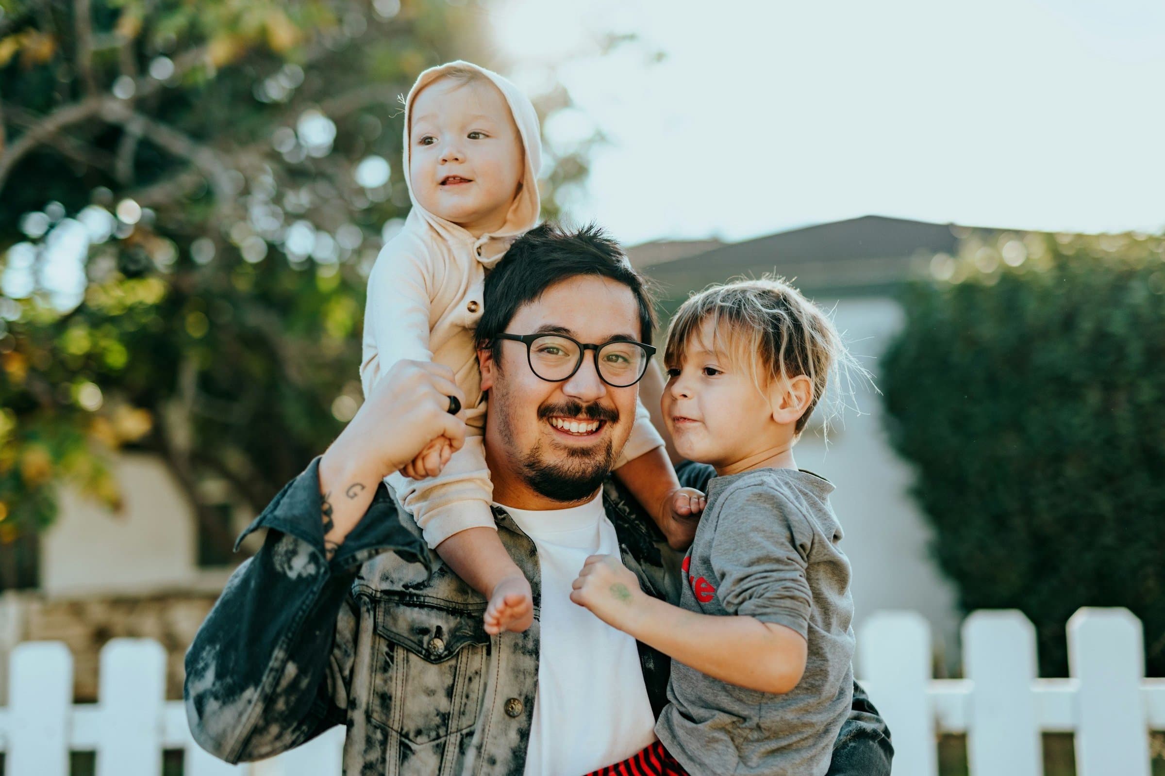 A smiling father with two young children