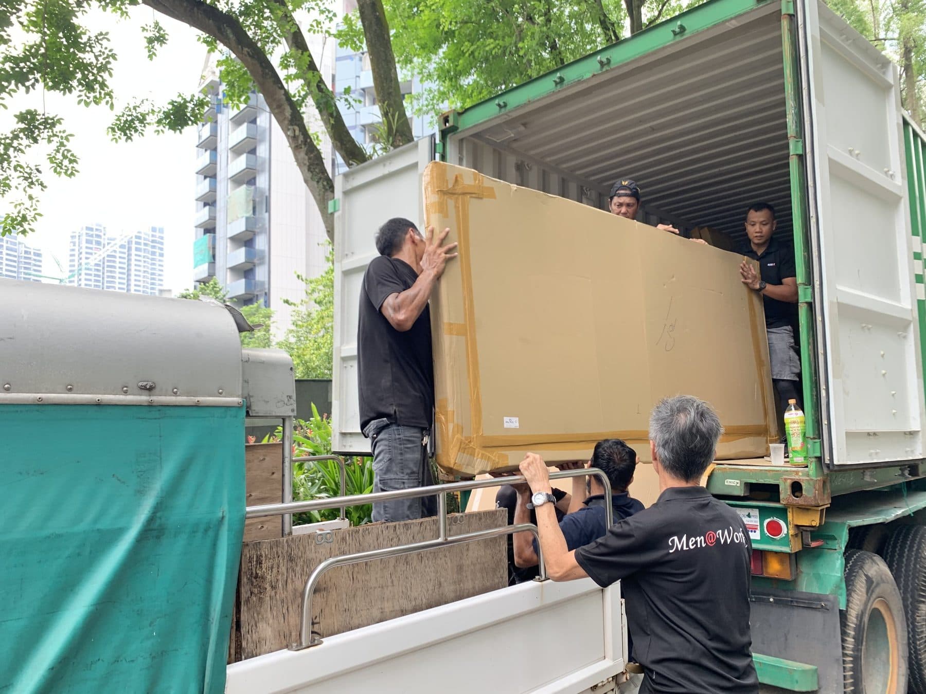 Reddot crew loading a large boxed item into a shipping container