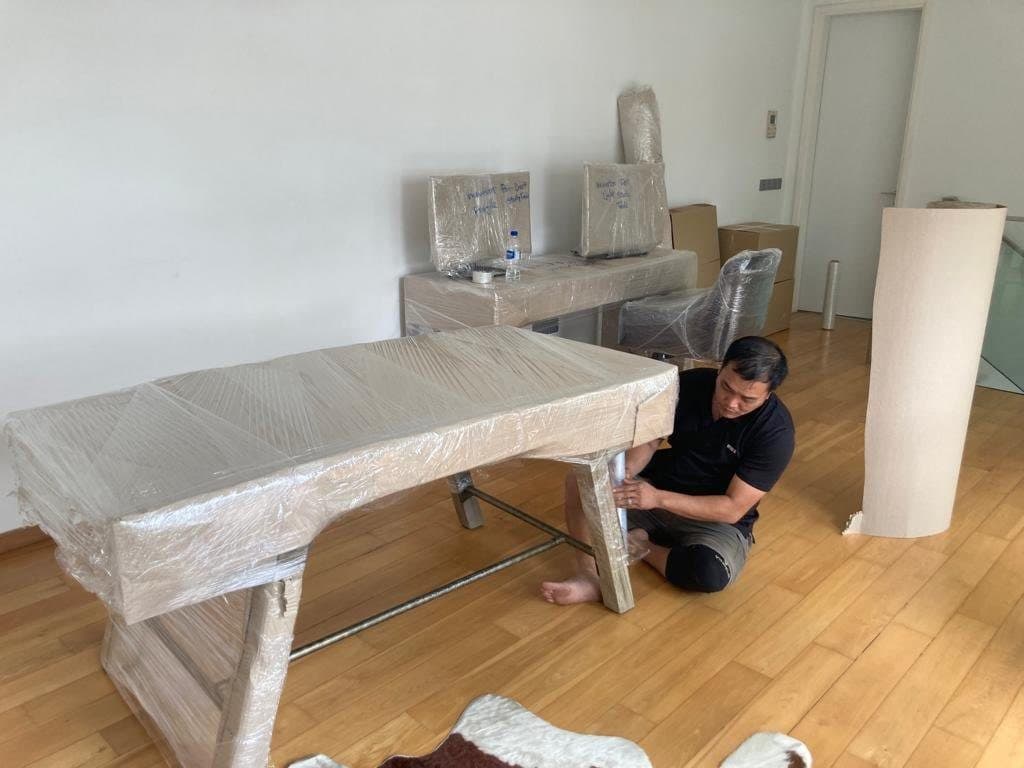 A Reddot mover wrapping a desk in protective film